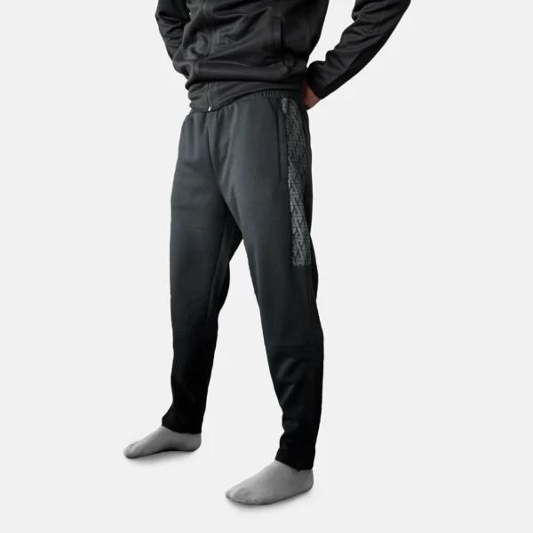 Svarta KOSA joggers / mujkisbyxa i polyester med mönstrad revär på sidan.
